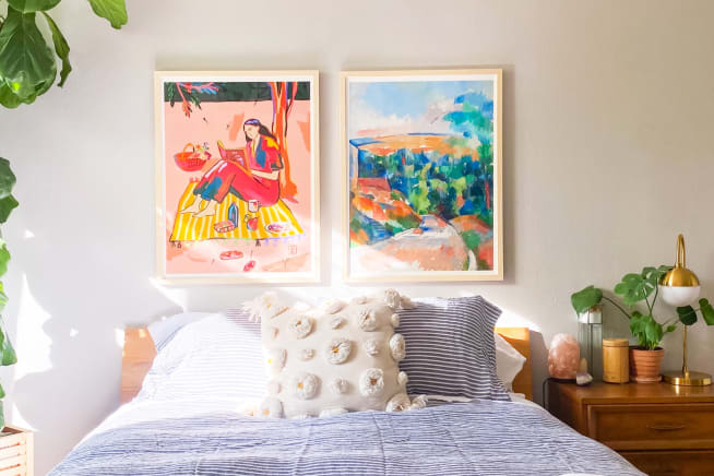 Bedroom with a tall fiddle leaf fig plant on to one side of the bed and a monstera on a bedside table